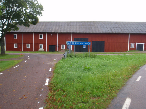 Right turn for Askersund in front of a big red barn.